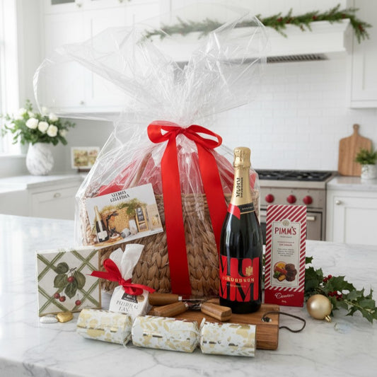 Gift basket with a bottle of Pimm's and crackers on a kitchen counter.