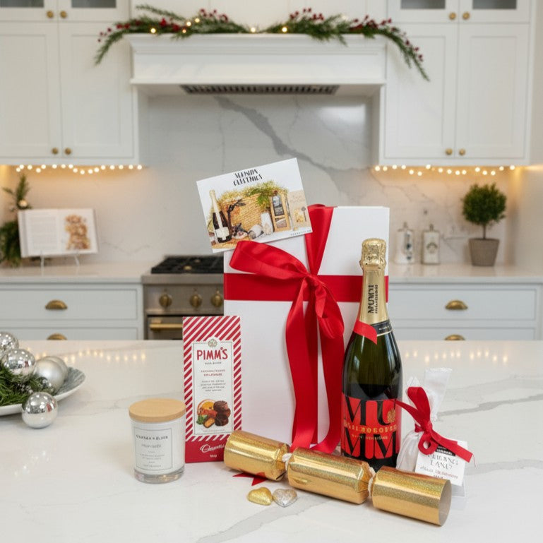 Gift basket with champagne, crackers, and Pimm's in a kitchen setting