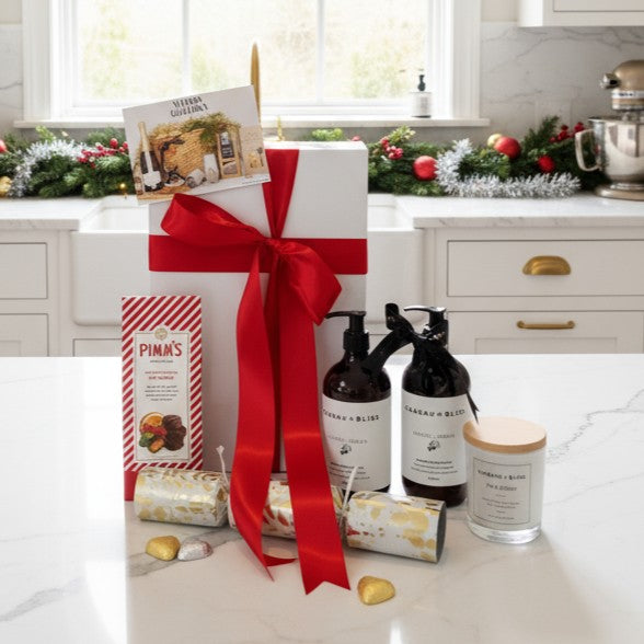 Gift set with Pimm's products on a kitchen counter, decorated for Christmas.