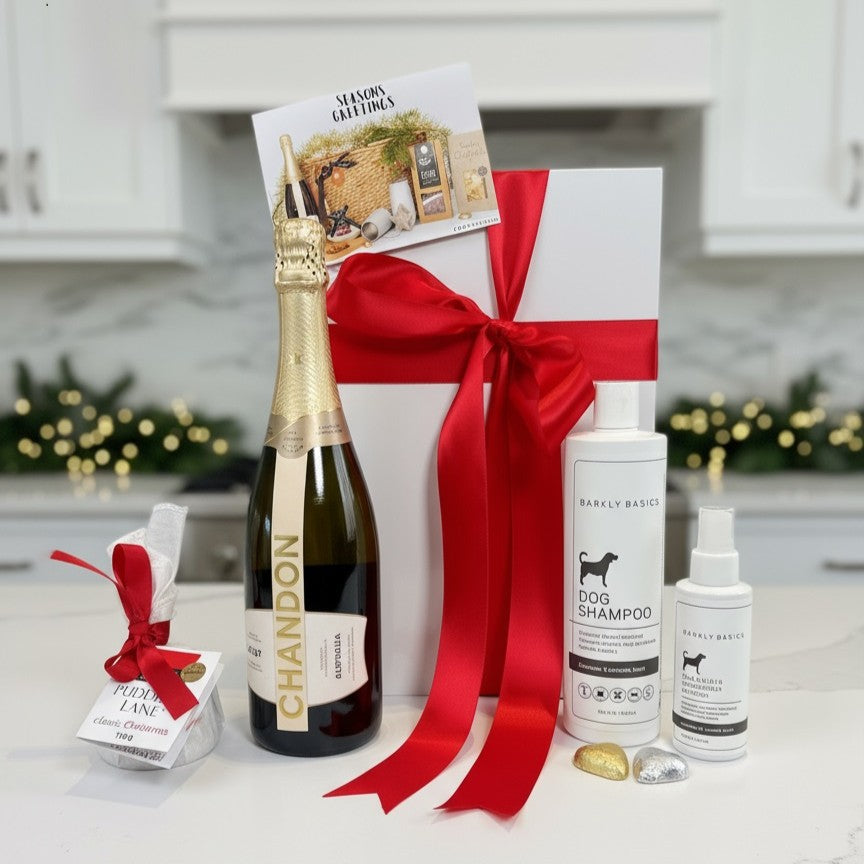 Gift basket with Chandon champagne, dog shampoo, and other items on a kitchen counter.